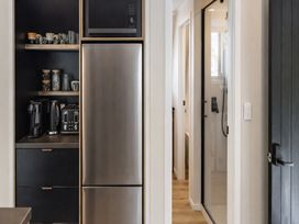 A kitchen with appliances and shelves at Peaks and Pines Chalet - Ohakune