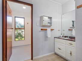 A bathroom with sink and mirror at Ocean Whispers - Whitianga Holiday Home