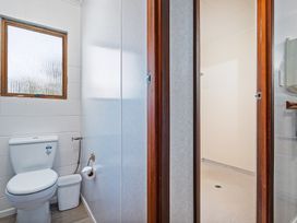 A bathroom with a toilet and shower at Ocean Whispers - Whitianga Holiday Home in Whitianga