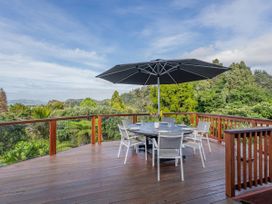An outdoor patio with a table and chairs under an umbrella at Coromandel