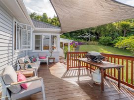 An outdoor deck with a gas barbecue and seating area at Coromandel