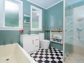 A bathroom with a bathtub, toilet, sink, and shower at Coromandel