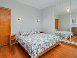 A bedroom featuring a bed and a mirror at Coromandel in Coromandel