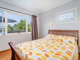 A bedroom with a bed and windows at Coromandel in Coromandel