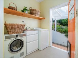A laundry room with a washing machine and drying machine at Coromandel