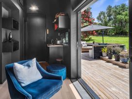A seating area with a chair and kettle at Black Dune in Waipu