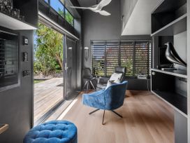 A living room with chairs and shelves at Black Dune in Waipu