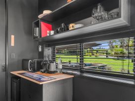 A kitchen with appliances and glassware at Black Dune in Waipu