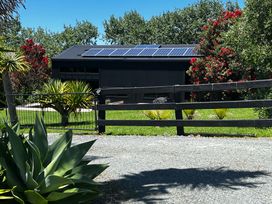 An outdoor view of a building with solar panels at Black Dune in Waipu