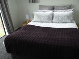 A bedroom with a bed and pillows at Moeraki Holiday Home, Moeraki