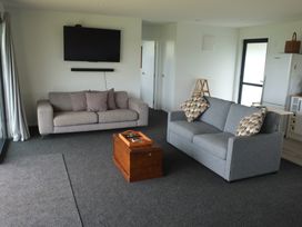 A living room with sofa and coffee table at Moeraki Holiday Home in Moeraki