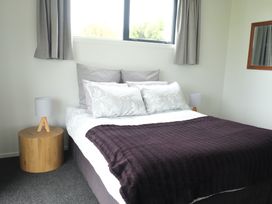 A bedroom with a bed and bedside tables at Moeraki Holiday Home in Moeraki