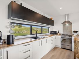 A kitchen with sink and stove at Seabreeze Lookout - Moeraki