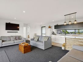 A living room with sofas and a television at Seabreeze Lookout - Moeraki