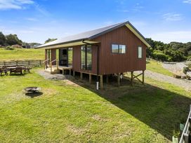A house with a deck and outdoor seating at Seabreeze Lookout - Moeraki