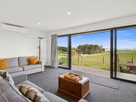 A living room with a sofa and coffee table at Seabreeze Lookout - Moeraki