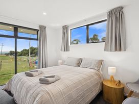 A bedroom with a bed and side table at Seabreeze Lookout - Moeraki Holiday Home