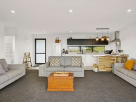 A living room with kitchen appliances and sofa at Seabreeze Lookout - Moeraki