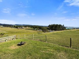 An outdoor view with grass, trees, and houses at Seabreeze Lookout - Moeraki