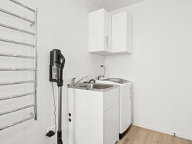 A laundry room with a sink and washing machine at Seabreeze Lookout - Moeraki