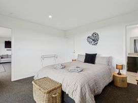 A bedroom with a bed and nightstand at Seabreeze Lookout - Moeraki