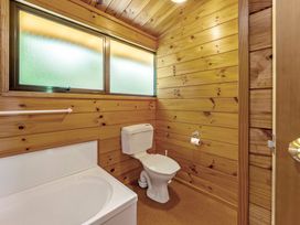 A bathroom with a bathtub and toilet at Lake Taupo Holiday Home in Turangi