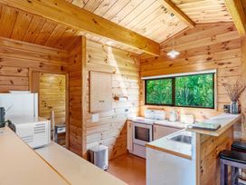 A kitchen with wooden cabinets and appliances at Lake Taupo Holiday Home in Turangi