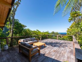 An outdoor deck with a sofa and coffee table at Lake Taupo Holiday Home in Turangi