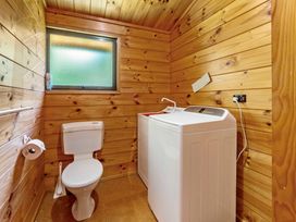 A bathroom with a washing machine and toilet at Lake Taupo Holiday Home in Turangi