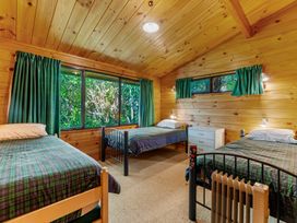 A bedroom with three beds and a dresser at Lake Taupo Holiday Home in Turangi