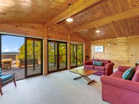 A living room with seating area and large windows at Lake Taupo Holiday Home in Turangi