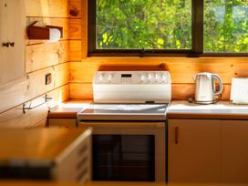 A kitchen with stove kettle and toaster at Lake Taupo Holiday Home in Turangi