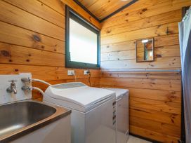 A laundry room with a washing machine and sink at Pauanui Sea Esta Pauanui