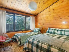 A bedroom with two beds and a window at Pauanui Sea Esta in Pauanui