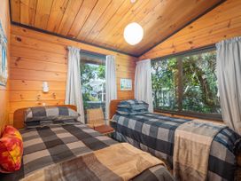 A bedroom with two beds and a window at Pauanui Sea Esta in Pauanui