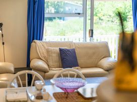 A living room with a sofa and a table at Lake Taupo Holiday Home in Turangi