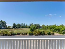 A view of trees and grass from the balcony at Lake Taupo Holiday Home in Turangi