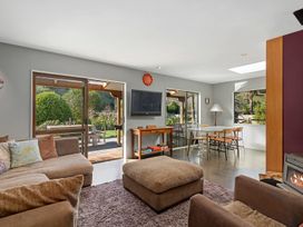 A living room with a sofa, television, and dining area at Brook Beauty - Nelson Holiday Home Nelson