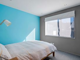 A bedroom with a bed and lamp at Brook Beauty - Nelson Holiday Home, Nelson