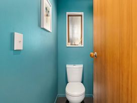A bathroom with a toilet and a window at Brook Beauty - Nelson Holiday Home in Nelson