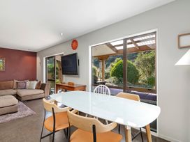 A living room with a sofa and dining table at Brook Beauty - Nelson Holiday Home, Nelson