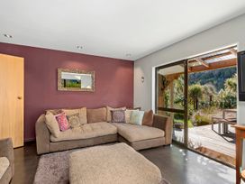 A living room with a sofa and mirror at Brook Beauty - Nelson Holiday Home, Nelson
