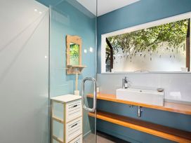 A bathroom with a shower, sink, and mirror at Brook Beauty - Nelson Holiday Home, Nelson
