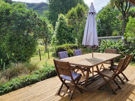 A table with chairs and an umbrella in a garden at Brook Beauty - Nelson Holiday Home, Nelson