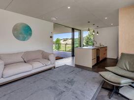 A living room with a sofa and kitchen area at Tutukaka in Whangarei