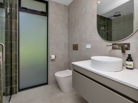 A bathroom with a shower, toilet, and sink at Tutukaka in Whangarei