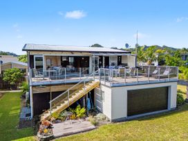 A house with a deck and garage at The Captain's Cabin Whitianga