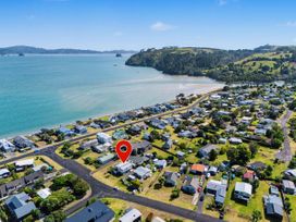 An aerial view of a coastal area with houses and water at Whitianga