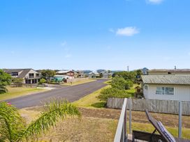 A view of houses along a road with grass and trees at Whitianga