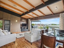 A living room with a sofa and dining table at Whitianga